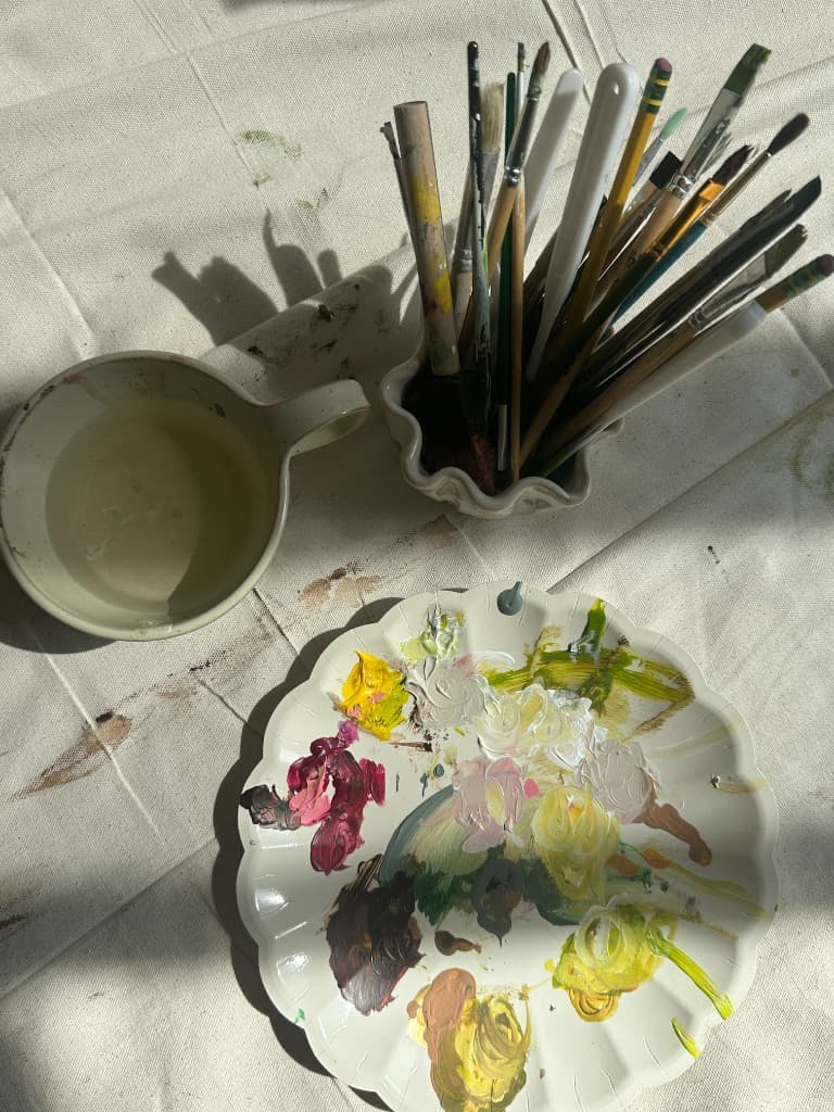 Paintbrushes and a paint-filled palette in the studio