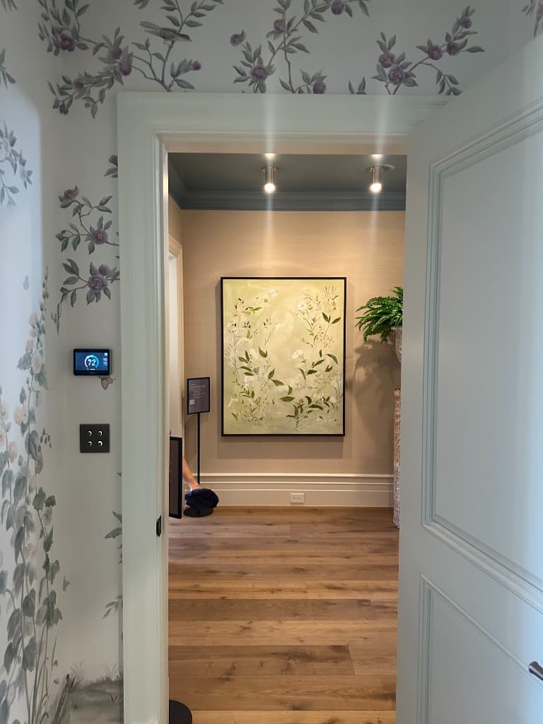 The green botanical painting hanging at the end of the hallway